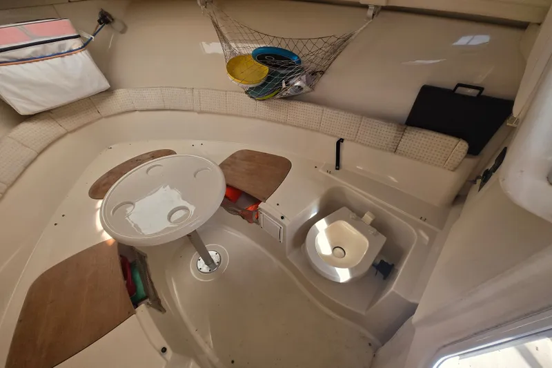 Slide: The Image of 2004 Wellcraft 252 Coastal cabin interior with seating, table, and storage. - 15