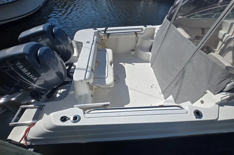 Slide: The Image of 2004 Wellcraft 252 Coastal boat with Yamaha engines, docked on calm water. - 4