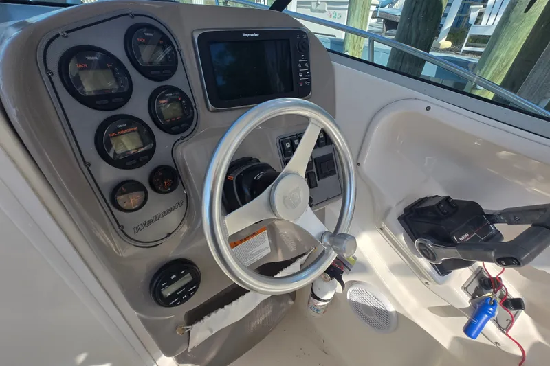 Slide: The Image of 2004 Wellcraft 252 Coastal boat dashboard with steering wheel and control panel. - 13