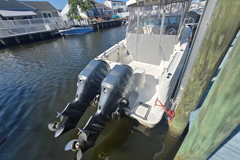Slide: The Image of 2004 Wellcraft 252 Coastal boat with twin Yamaha outboard motors docked in a marina. - 3