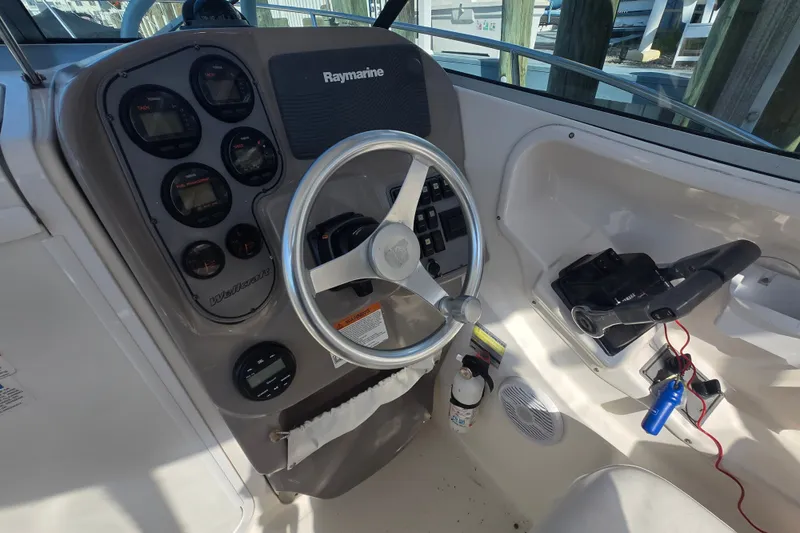 Slide: The Image of 2004 Wellcraft 252 Coastal boat dashboard with steering wheel and Raymarine electronics. - 11