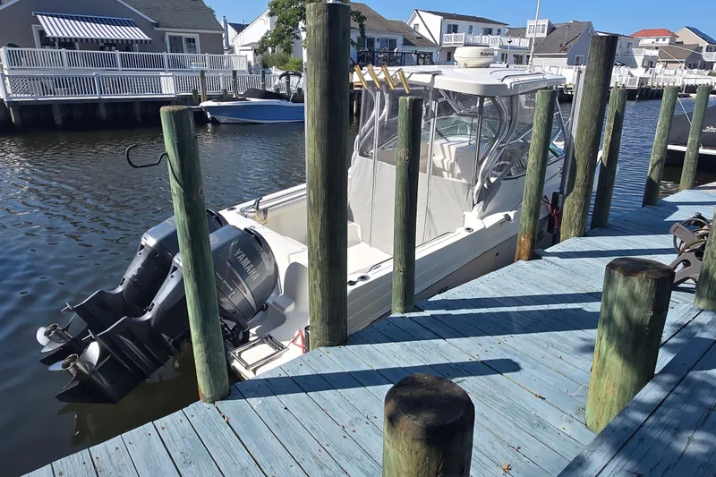 Slide: The Image of 2004 Wellcraft 252 Coastal boat docked with Yamaha engines, in a residential marina setting. - 19