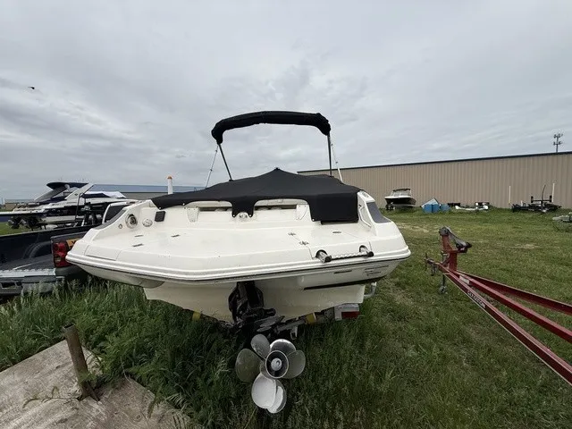 Slide: The Image of A white boat with a black canopy is on grass next to a trailer. - 4