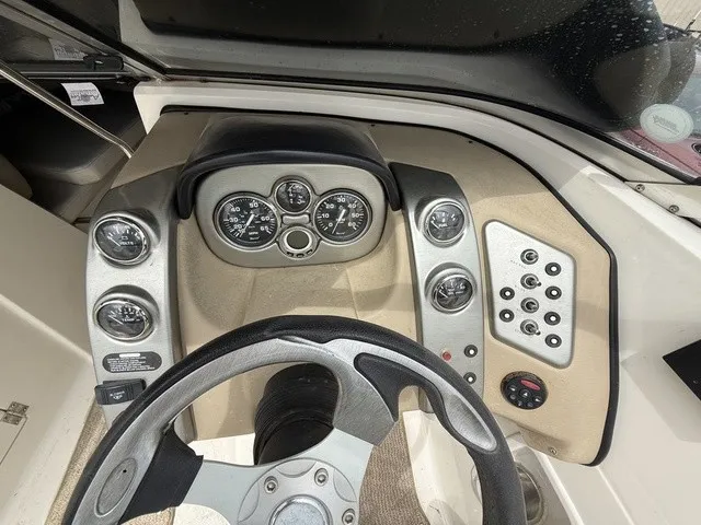 Slide: The Image of The image shows the dashboard of a 2007 Larson LXi 268 boat with multiple gauges and controls. - 12