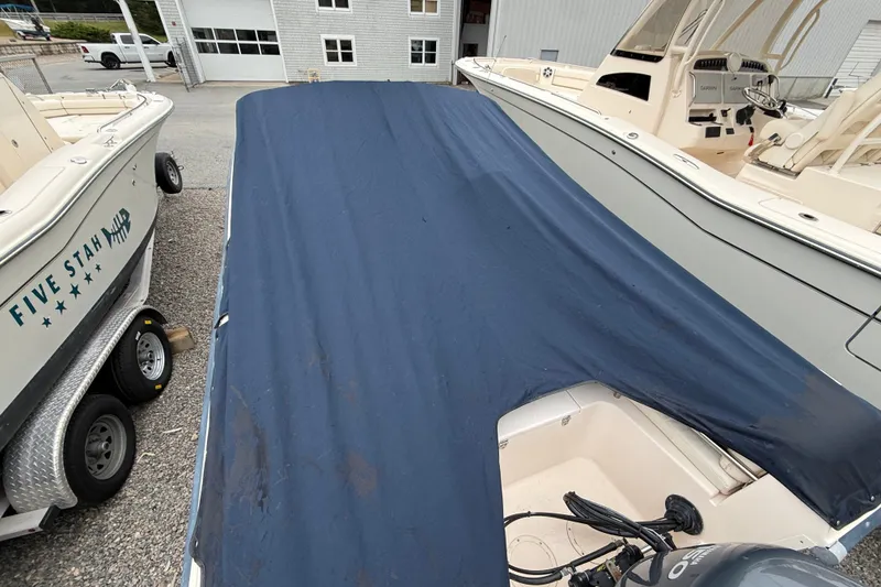 Slide: The Image of 2007 Grady-White Tournament 205 boat with blue cover, parked beside another boat. - 32