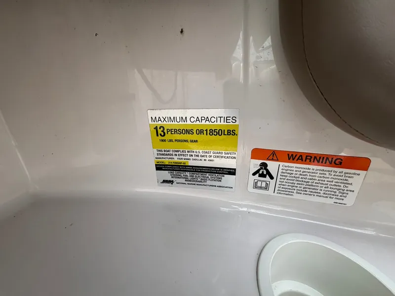 Slide: The Image of A warning label on a boat indicates a maximum capacity of 13 persons or 1850 pounds. - 28