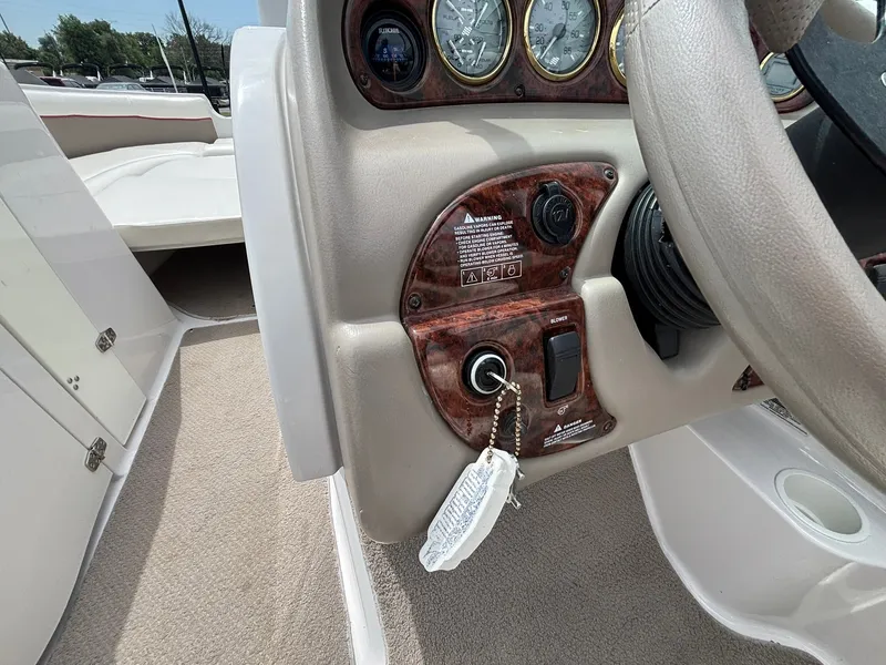 Slide: The Image of The image shows the dashboard of a 2003 Four Winns 214 Fun Ship with wood paneling and instruments. - 26