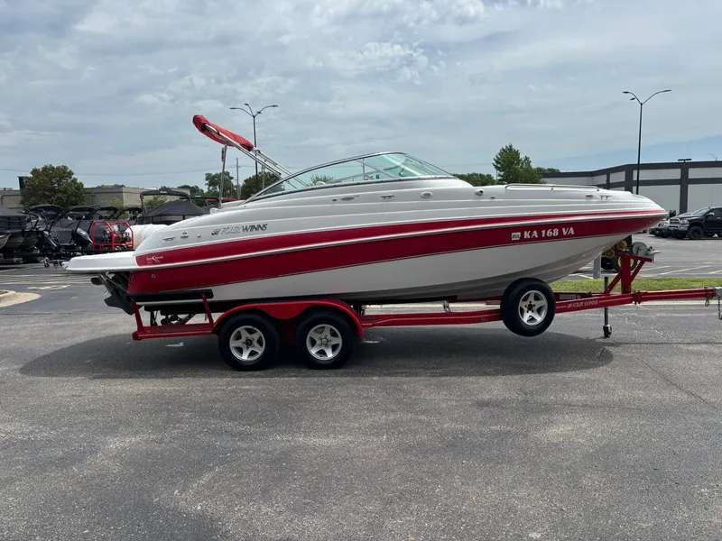 Slide: The Image of A 2003 Four Winns 214 Fun Ship on a red trailer, parked in a lot. - 4