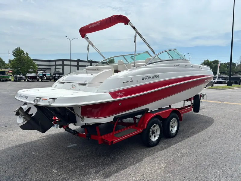 Slide: The Image of A 2003 Four Winns 214 Fun Ship on a red trailer. It features a white and red design. - 5