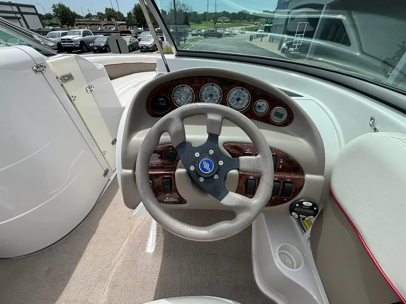 Slide: The Image of The image shows the cockpit of a 2003 Four Winns 214 Fun Ship with a sleek steering wheel and dashboard. - 24