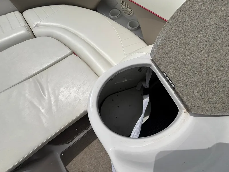 Slide: The Image of An open storage compartment on a boat with white upholstered seating. - 32
