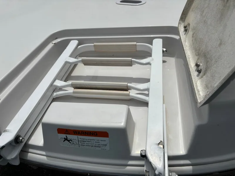 Slide: The Image of A folded swim ladder on a boat with a warning label. - 9