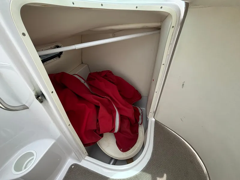 Slide: The Image of A small storage area in the boat with a red jacket and a seat. - 23