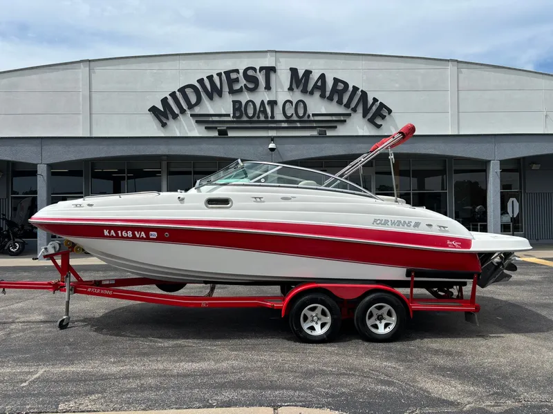 The Image of A 2003 Four Winns 214 Fun Ship on a red trailer in front of a boat company. - 1