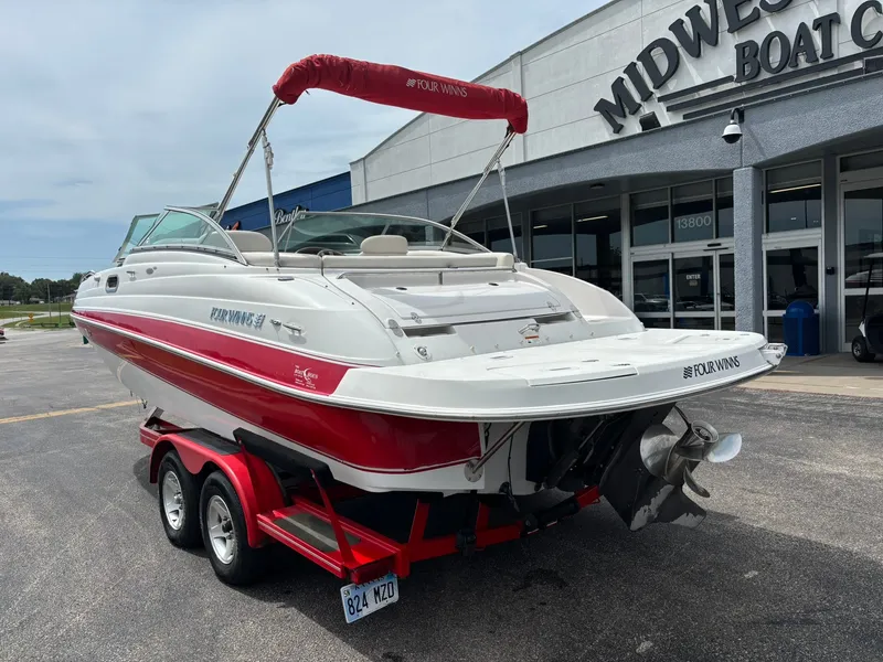 Slide: The Image of A white and red boat on a trailer in front of a boat center. It has a red sunshade. - 7