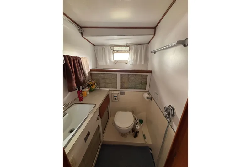 Slide: The Image of Bathroom interior of 1969 Hatteras 38 Double Cabin yacht, featuring sink and toilet. - 22