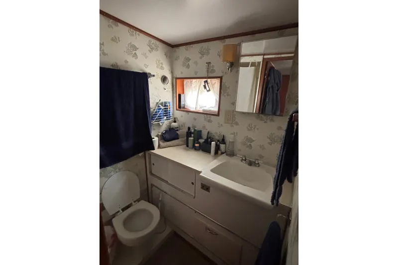 Slide: The Image of Bathroom interior of 1969 Hatteras 38 Double Cabin with sink, toilet, and mirror. - 27