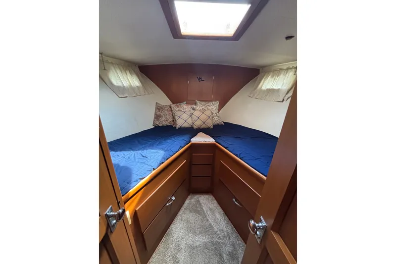 Slide: The Image of Cozy cabin interior of 1969 Hatteras 38 Double Cabin with blue bedding and wooden storage. - 19