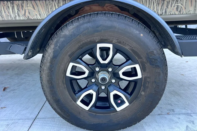 Slide: The Image of 2025 Tracker Grizzly 1650 T Prairie Wings Edition wheel with black and silver rim design. - 29
