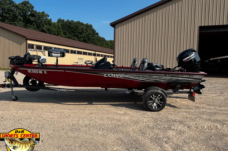 Slide: The Image of 2020 Lowe Stinger 175C fishing boat with Mercury engine, parked outside a storage building. - 1