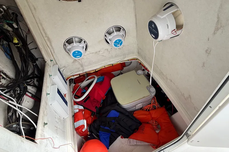 Slide: The Image of Storage compartment of a 1998 Boston Whaler 23 Outrage with life jackets and marine speakers. - 10