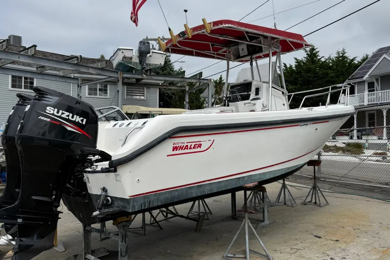 Slide: The Image of 1998 Boston Whaler 23 Outrage boat with Suzuki outboard motor on dry dock. - 1