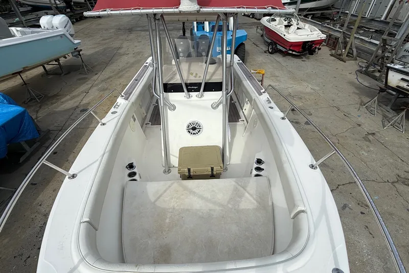 Slide: The Image of 1998 Boston Whaler 23 Outrage boat interior with seating and console, docked in a marina. - 7