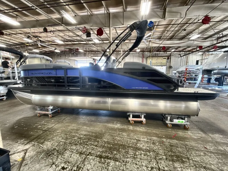 The Image of The image shows a 2027 Bennington 22 M Swingback pontoon boat in a warehouse. - 1