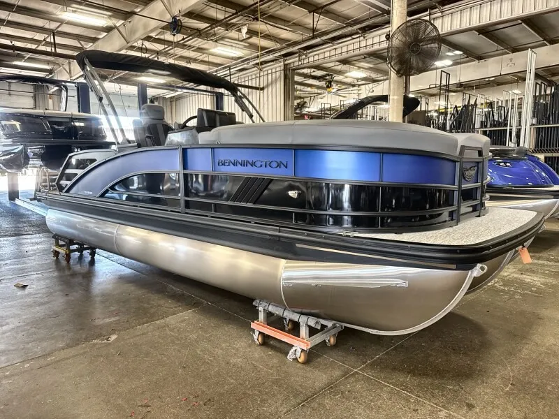 Slide: The Image of A 2027 Bennington 22 M Swingback pontoon boat in a warehouse. It features a modern design with blue accents. - 4