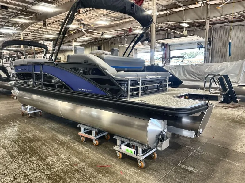 The Image of A 2027 Bennington 22 M Swingback pontoon boat is on dollies in a warehouse. - 1