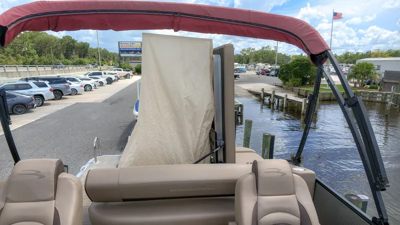 Slide: The Image of The image shows a 2022 Bennington 22 LSB pontoon boat with beige seats and a red canopy. - 6