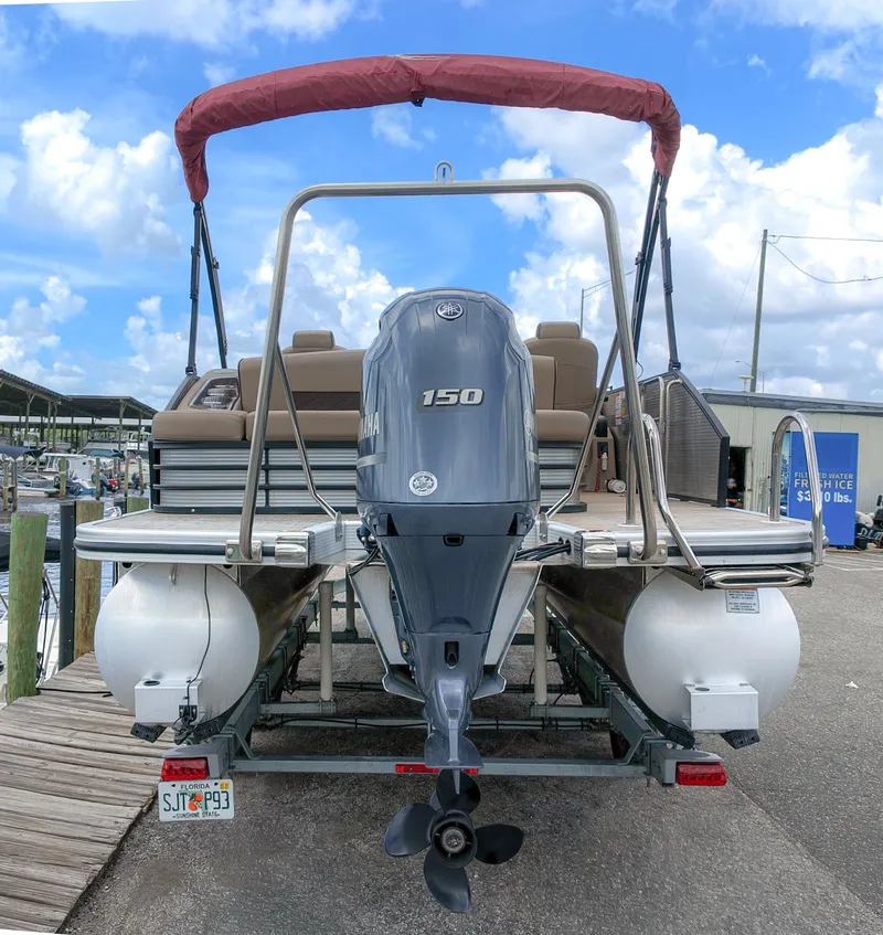 Slide: The Image of The image shows a 2022 Bennington 22 LSB pontoon boat with a Yamaha 150 outboard motor. - 2