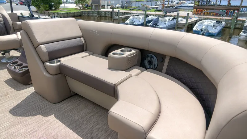 Slide: The Image of The image shows a luxurious beige upholstered seating area on a boat, with cup holders and speakers. - 9