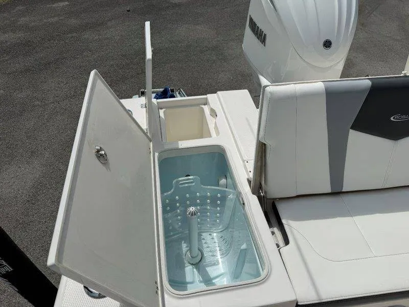 Slide: The Image of The image shows the rear area of a Robalo 246 Cayman boat with an open storage compartment. - 32