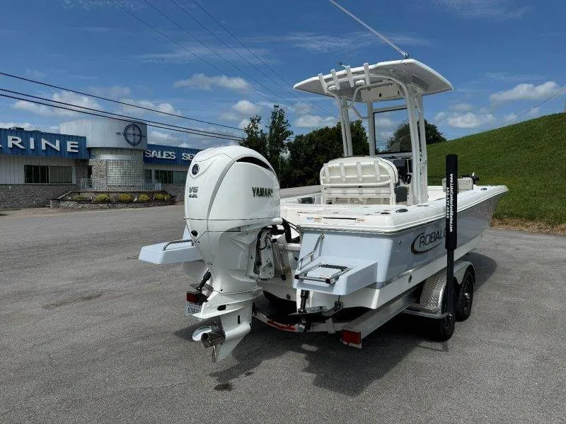 Slide: The Image of A 2023 Robalo 246 Cayman boat on a trailer in front of a building. It has a Yamaha outboard motor. - 5