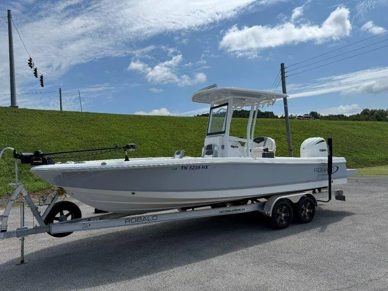 Slide: The Image of A 2023 Robalo 246 Cayman on a trailer, featuring a T-top and outboard motor. - 3