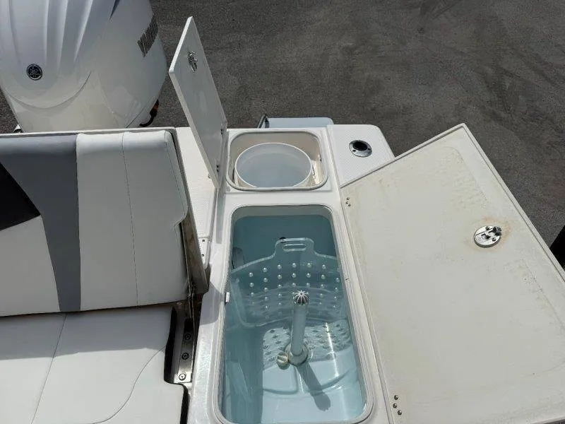 Slide: The Image of The image shows the rear area of a Robalo 246 Cayman boat with an open storage compartment. - 39