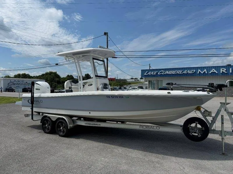 Slide: The Image of A 2023 Robalo 246 Cayman on a trailer in front of a marina. - 6