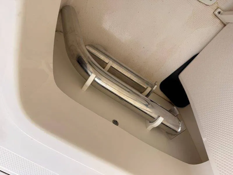 Slide: The Image of Close-up of a stainless steel handle on a boat, surrounded by white upholstery and flooring. - 34