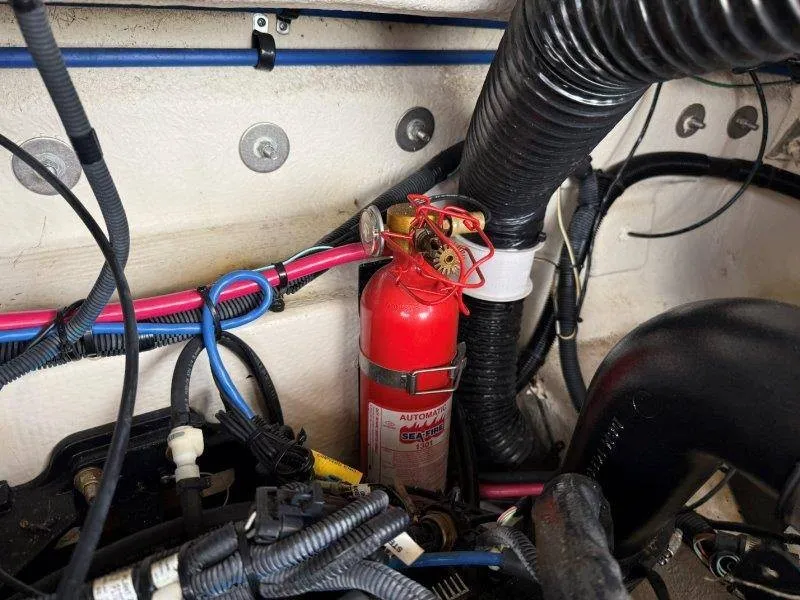 Slide: The Image of A fire extinguisher is mounted in a boat engine compartment, surrounded by cables and hoses. - 35