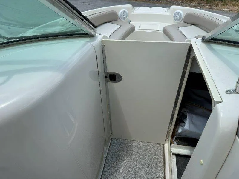 Slide: The Image of The 2003 Sea Ray 240 Sundeck features an open bow area with cushioned seating and a storage compartment. - 50