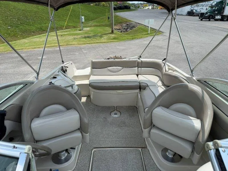 Slide: The Image of Interior of a 2003 Sea Ray 240 Sundeck boat with beige seating and gray carpet. - 43