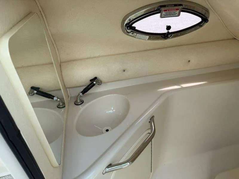 Slide: The Image of Interior of the 2003 Sea Ray 240 Sundeck with a sink and porthole. - 49