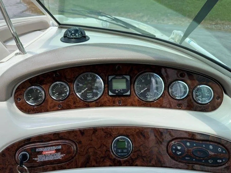 Slide: The Image of Dashboard of a 2003 Sea Ray 240 Sundeck with wood paneling and various gauges. - 34