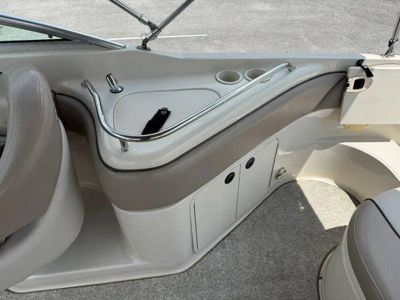 Slide: The Image of Interior view of a 2003 Sea Ray 240 Sundeck with beige upholstery and cup holders. - 37