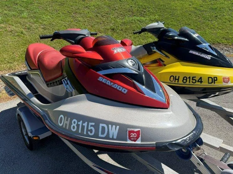 Slide: The Image of Two Sea-Doo jet skis on trailers, one red and one yellow, parked on pavement. - 12