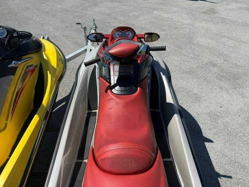 Slide: The Image of Two Sea-Doo jet skis, one red and one yellow, are on a trailer in a parking lot. - 25