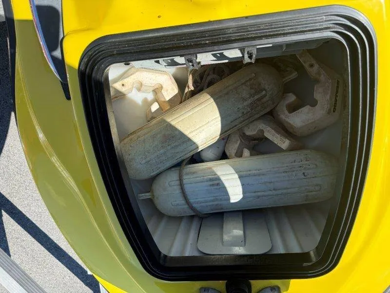 Slide: The Image of A yellow storage compartment with several white fenders and ropes. - 13