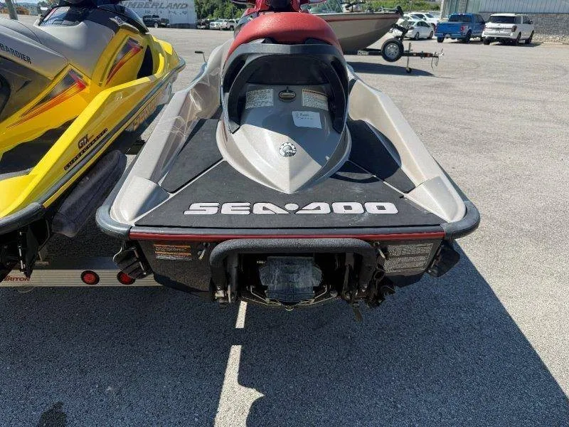 Slide: The Image of Two Sea-Doo jet skis, one yellow and one gray, are on a trailer in a parking lot. - 9