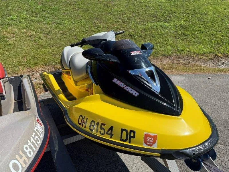 Slide: The Image of A yellow Sea-Doo jet ski is on a trailer on a grassy area. - 15